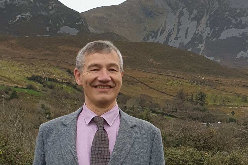 Man standing in front of mountains in Mayo.