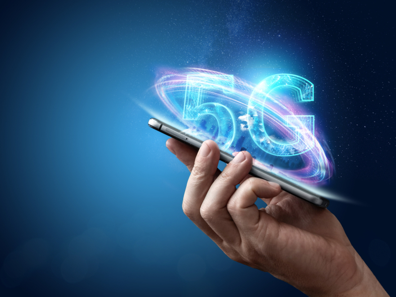 Person holding a phone with letters 5G coming out of it