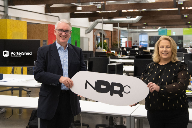 Man and woman holding NDRC sign.