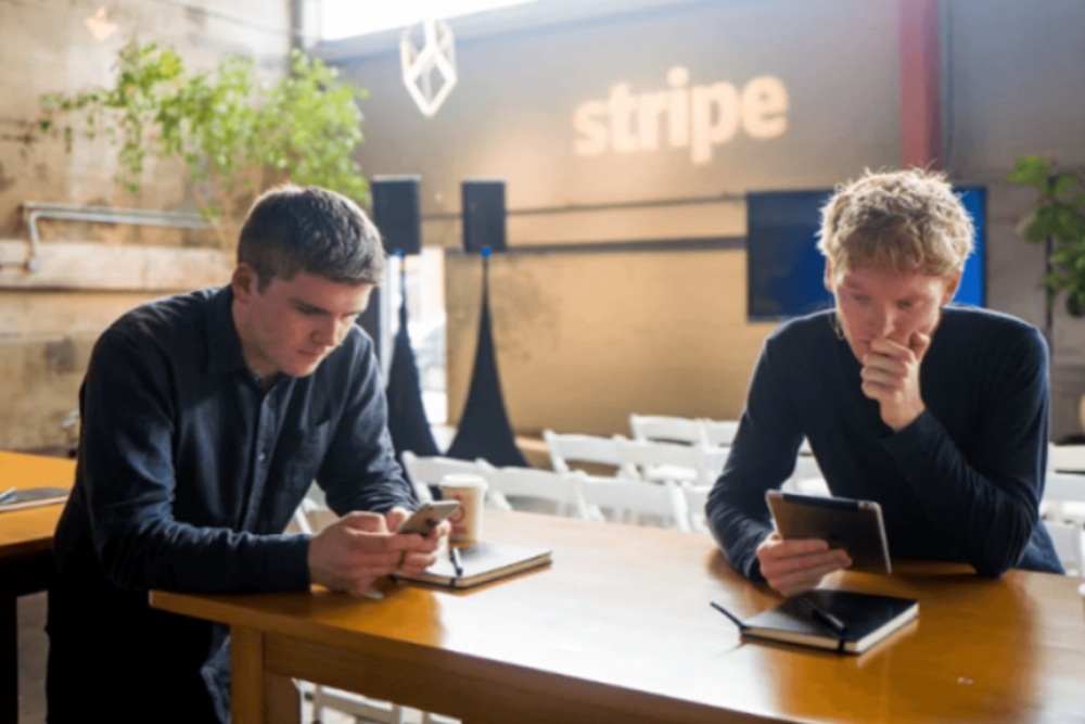 Two young founders of Stripe sitting at a table.
