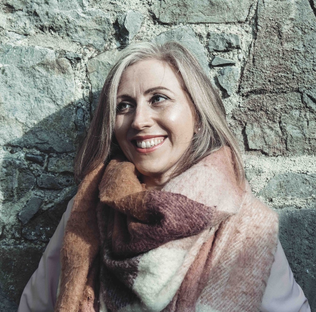 Blonde woman wearing a scarf.