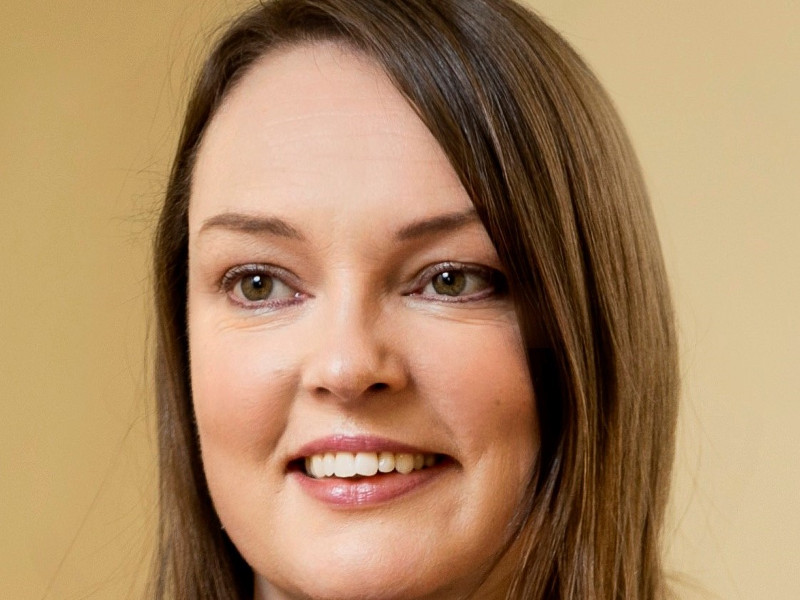 Smiling woman with brown hair and brown eyes.