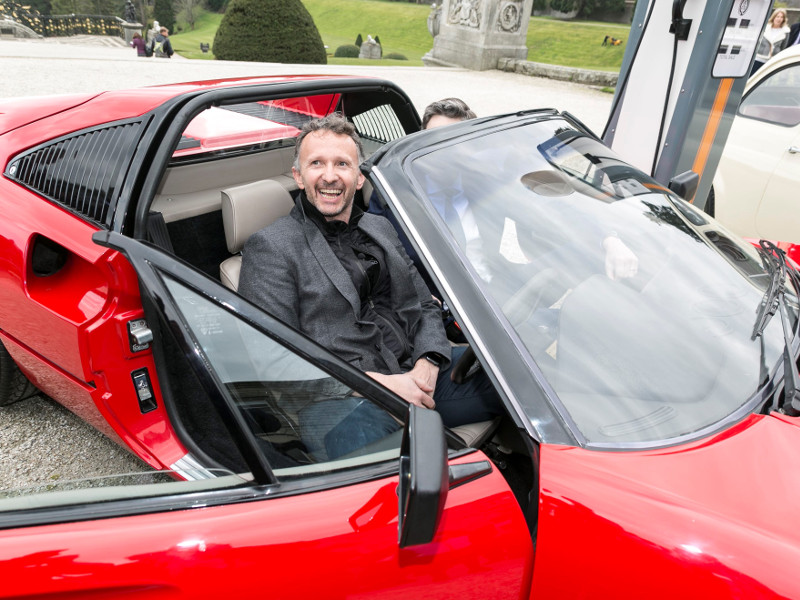 Smiling man in driving seat of an electrical Ferrari.