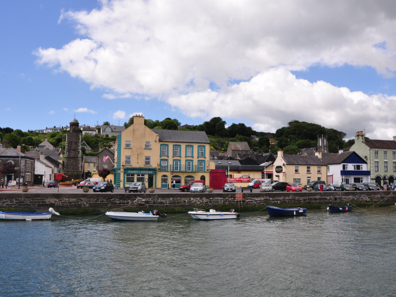 Beautiful view of Youghal harbour with boats in front of shops and pubs.