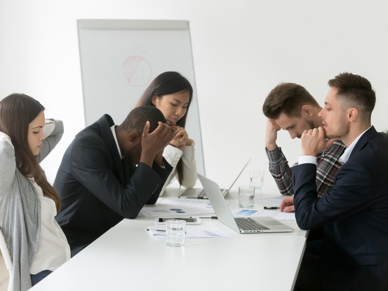 Team of workers absorbs news of failure.