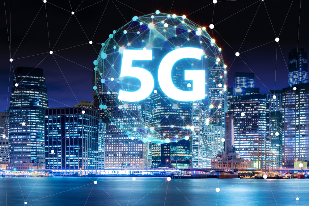 5G written inside a constellation of light in a big city.