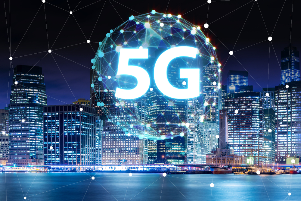 5G written inside a constellation of light in a big city.