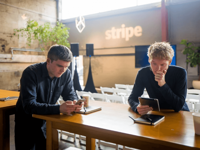 Two young men using electronic devices.