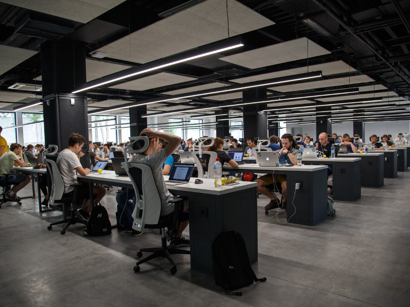 An open plan office with dozens of people working at computers.