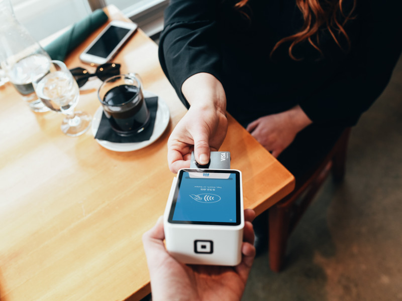 woman paying for coffee with a payment card