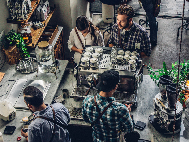 People at work in a busy coffee shop.