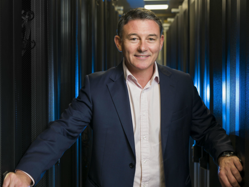 Man in blue suit standing in the middle of servers.