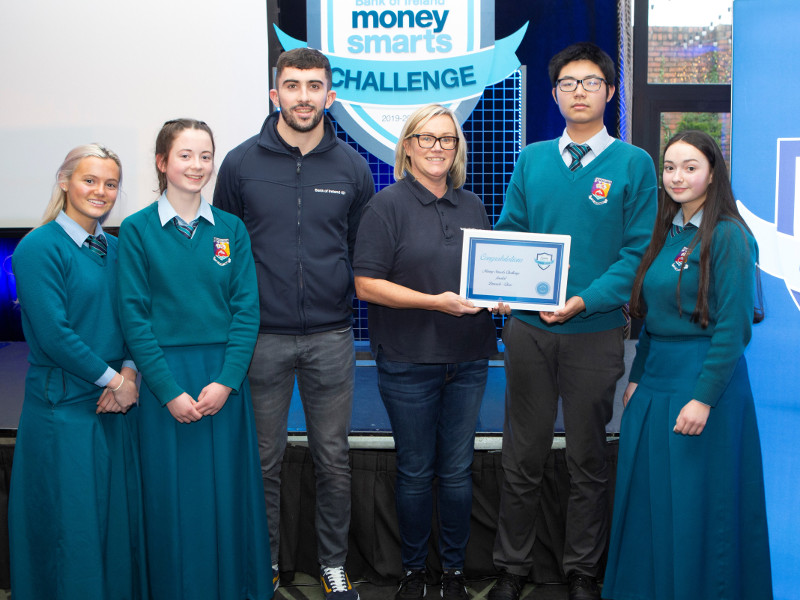 School students, teacher and sports star holding a certificate.