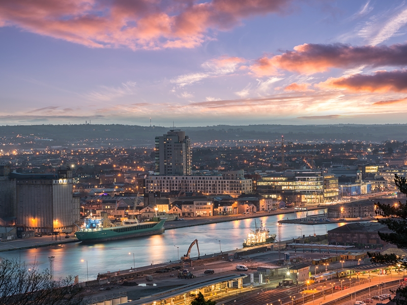 View of Cork city in the evening under blue sky and purple clouds.