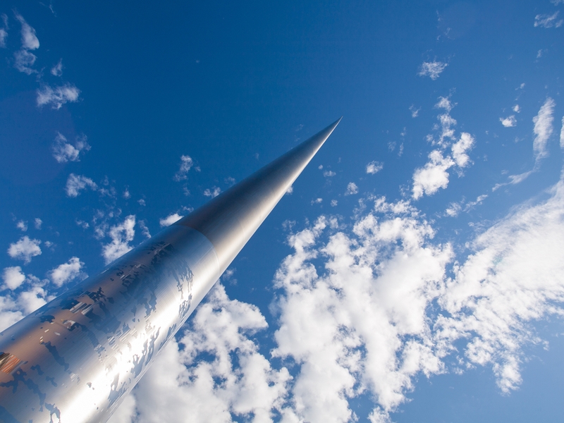 spire in Dublin reaching into clouds.