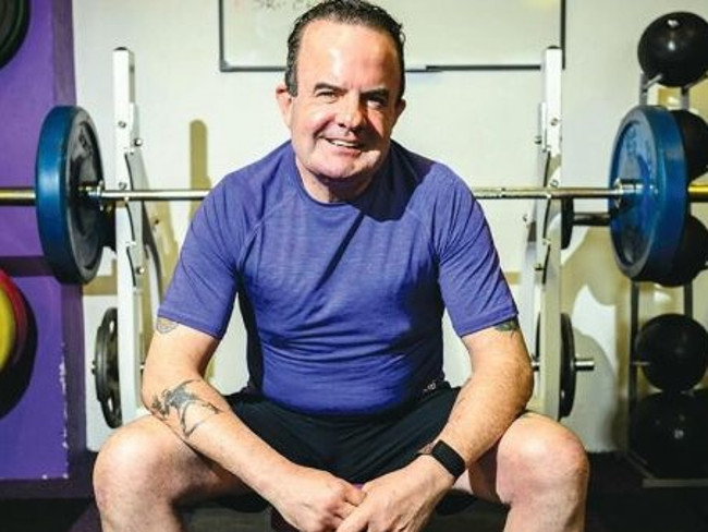 Man sitting on bench in gym.