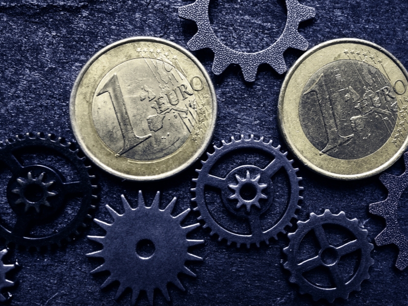 Euro coins between cogs and wheels.