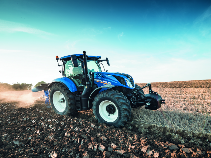 Blue tractor going over terrain.