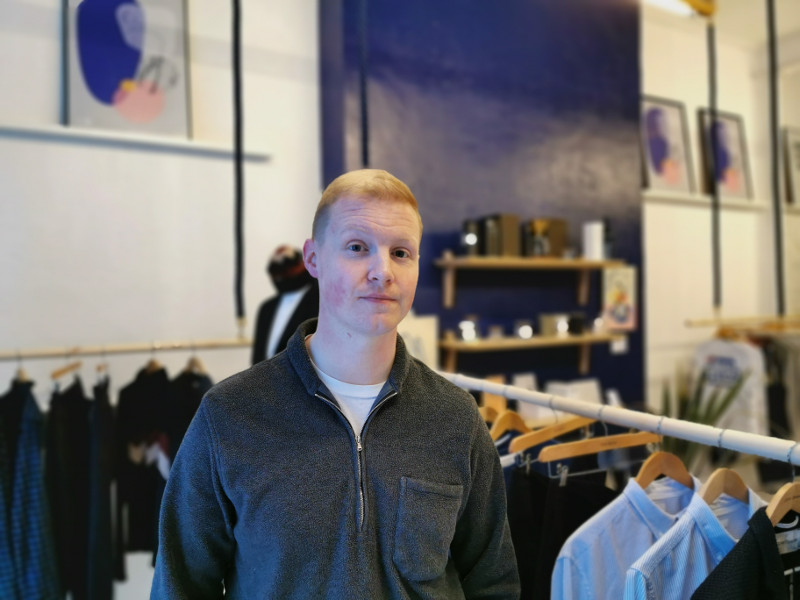 Young man with red hair in a clothes shop.