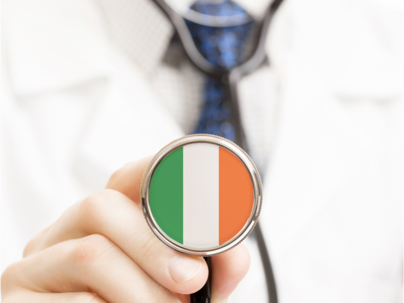 Doctor holding stethoscope with Irish flag on it.
