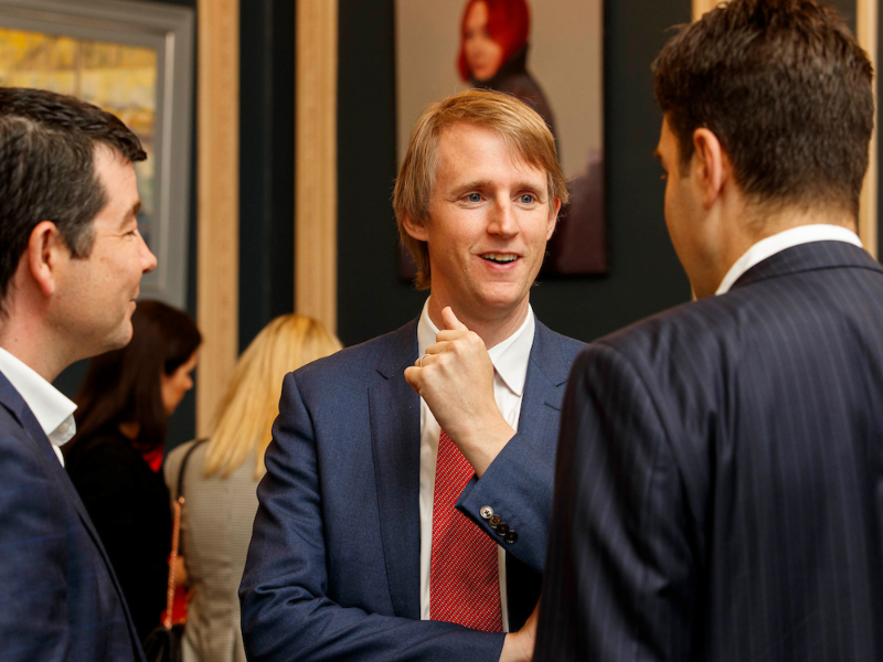 Man in suit chatting at an event.