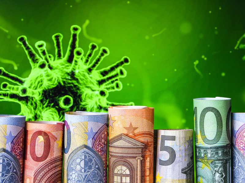 rolls of cash in front of a green virus image.