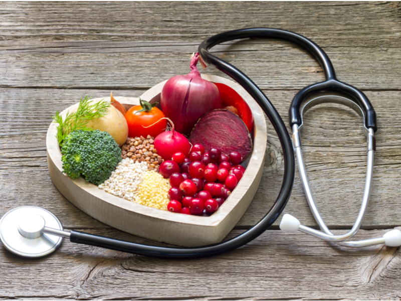 Heart-shaped bowl of healthy food with a stethoscope.