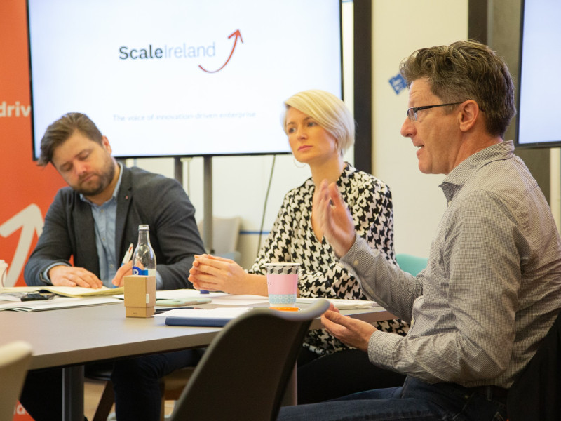 Two men and a woman at a conference table.