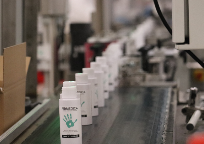 Airmedica hand sanitiser bottles on assembly line.