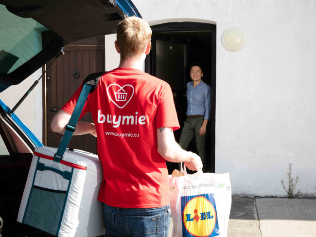 Person in Buymie shirt delivering groceries.