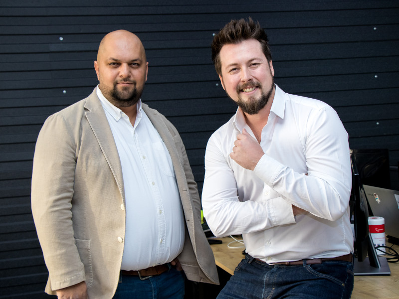 Two men with beards smiling.