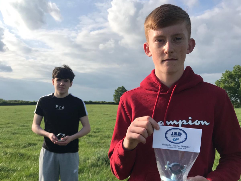 Two young students holding a product they invented.