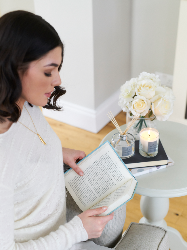 Dark-haired woman reading a book.