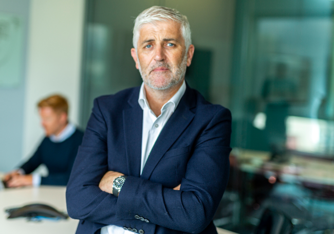 man in suit with arms folded.