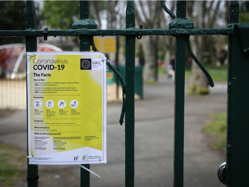 Covid facts sign on a park gate.