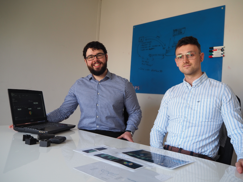 Two young men sitting at a desk.