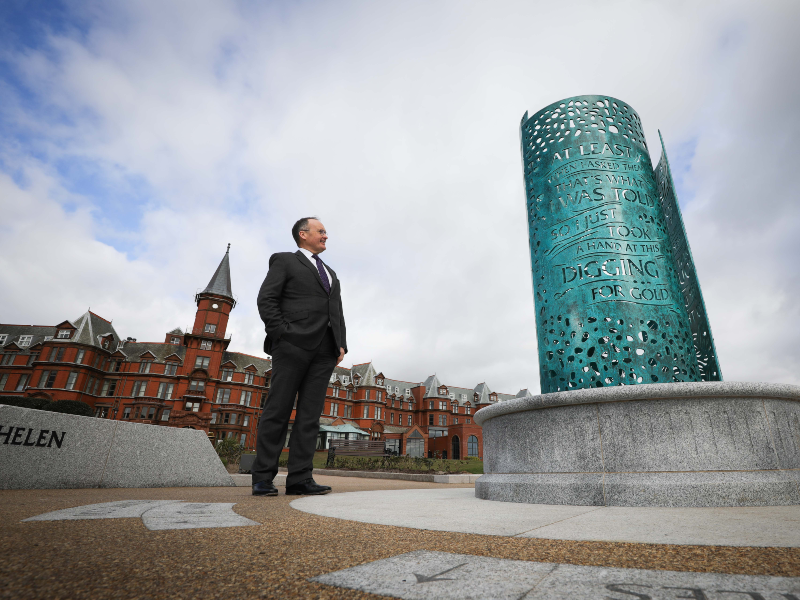 Man standing beside Percy French memorial.