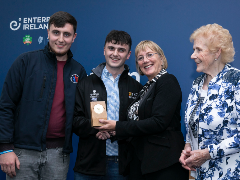 Two men receiving an award from two women.