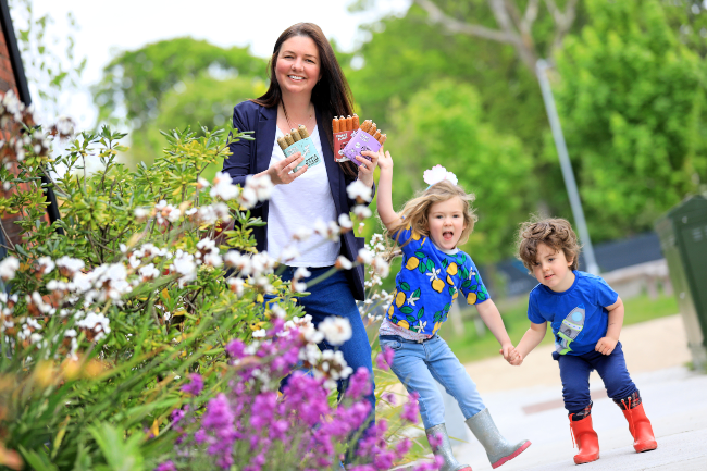 Woman standing in a garden with her two children.