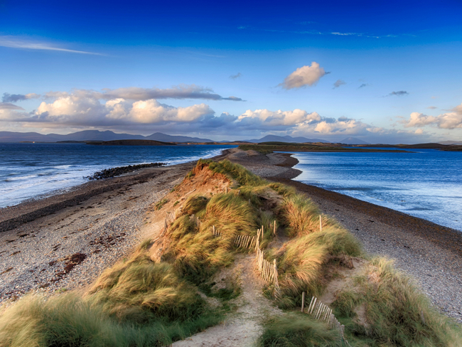 Sandy beach intersects sea.