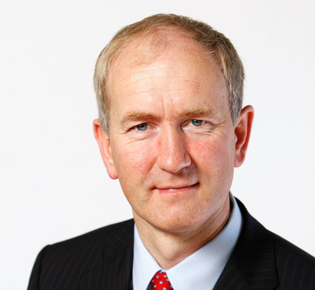 Man in dark suit with red tie.