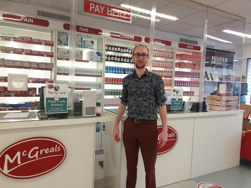 Man in glasses standing in a pharmacy.
