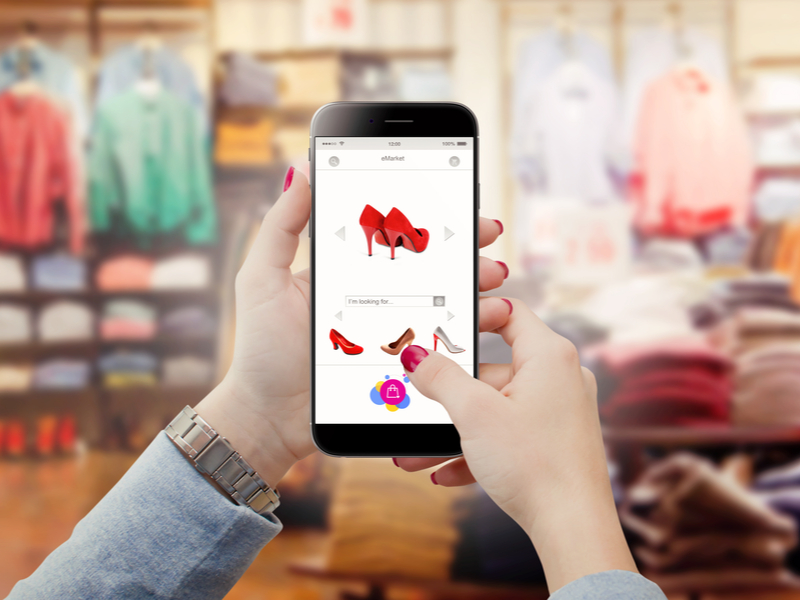 Consumer looking at shoes on a smartphone while in a store.