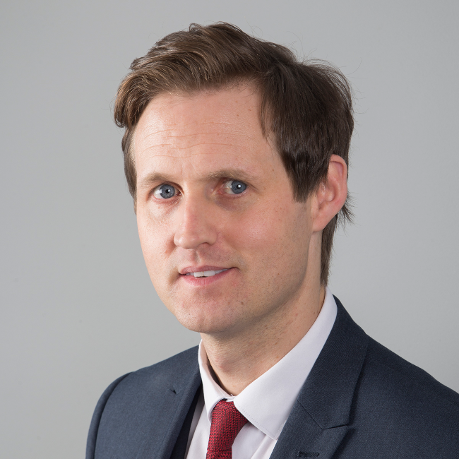 dark haired man in suit.