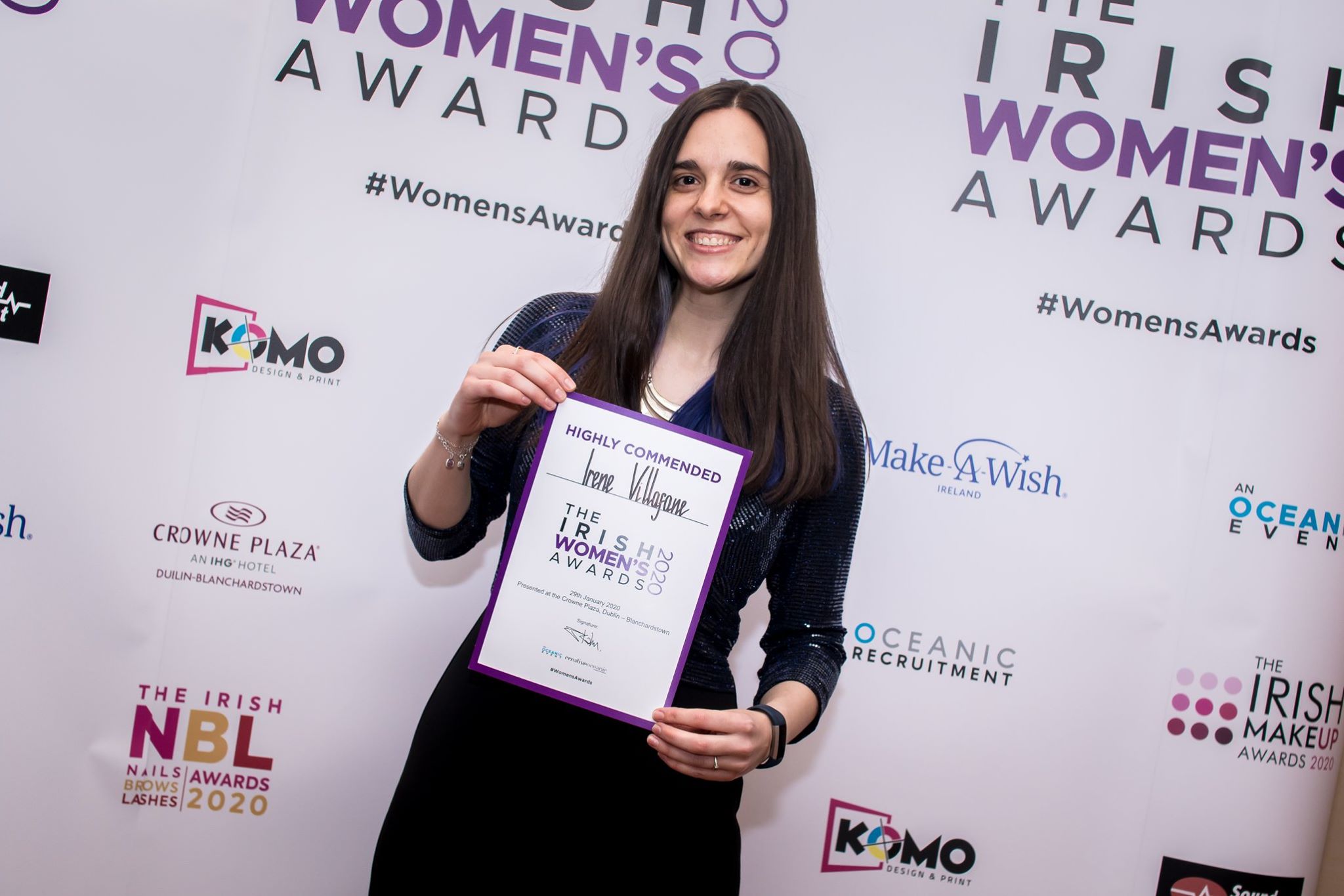 Dark-haired woman holding a certificate.