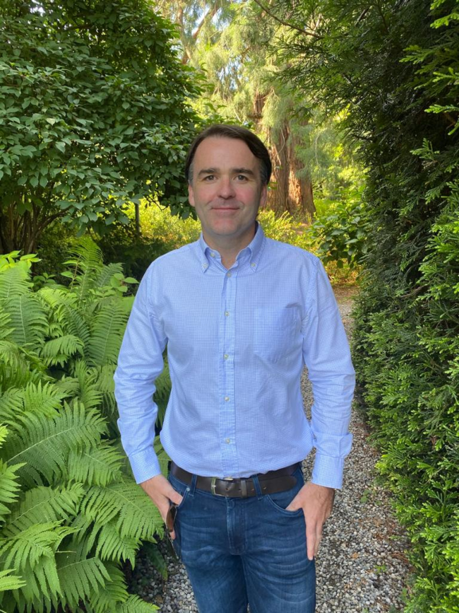 Man in blue shirt in garden.