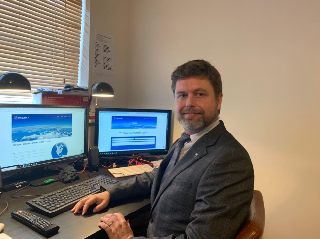 Man in suit sitting at desk.