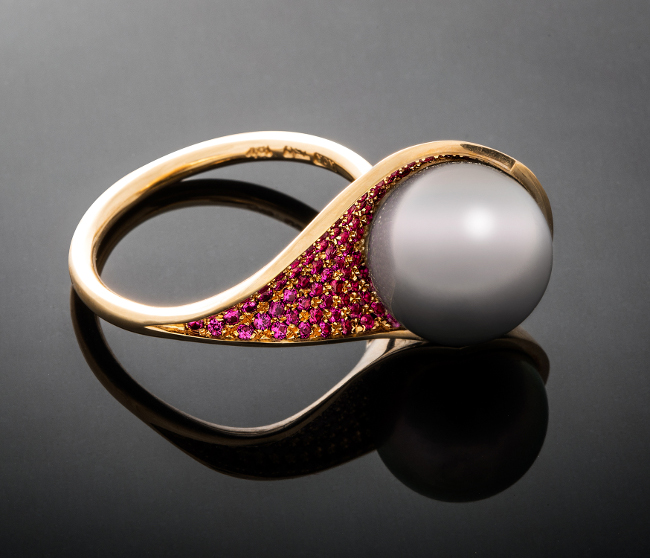 A pearl ring surrounded by diamonds.