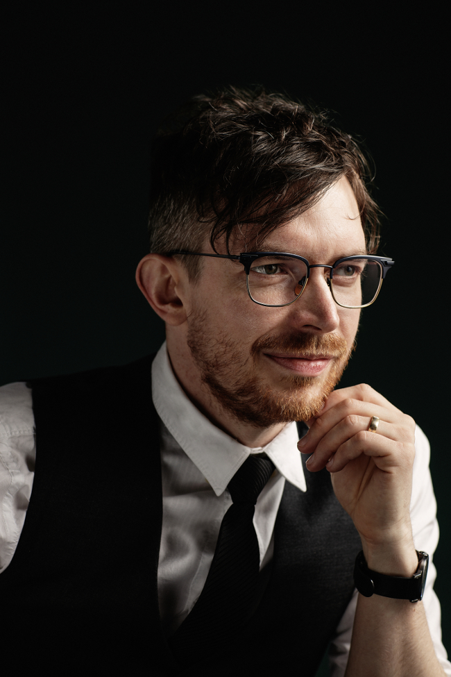 Man in glasses wearing a waistcoat and tie.