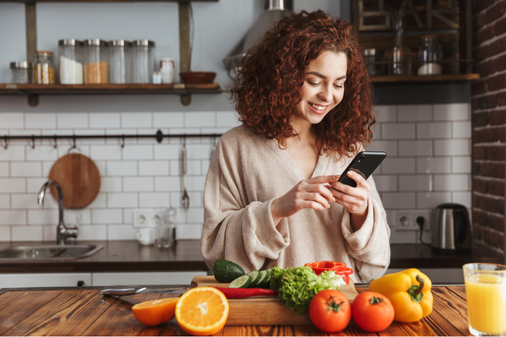 woman using her smartphone in kitchen.